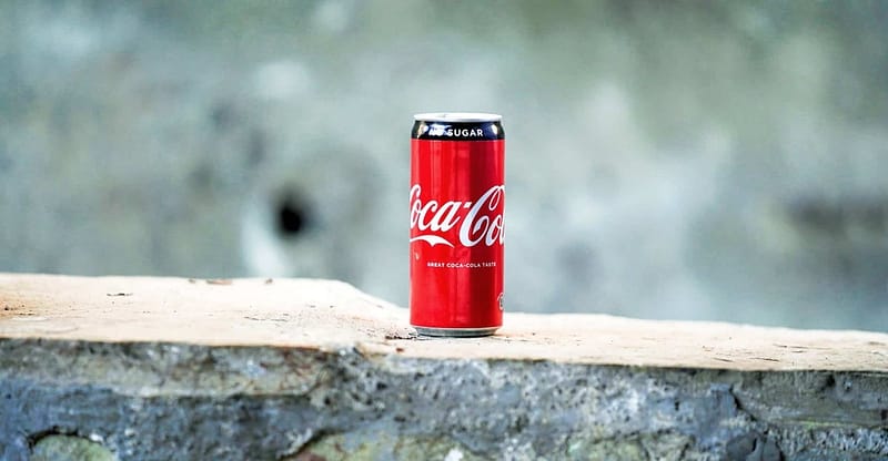 coca cola can on brown concrete surface